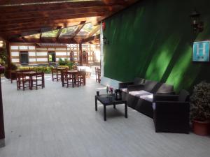 a patio with couches and tables and a green wall at Hotel El Repelao in Covadonga