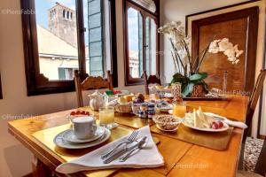 a wooden table with breakfast food on it at La Villeggiatura in Venice