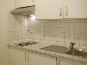 a kitchen with a sink and a stove at NewLivingHome Residenzhotel Hamburg in Hamburg