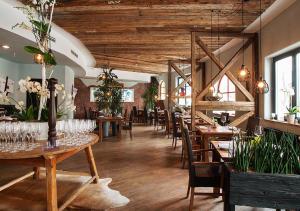 a restaurant with wooden ceilings and tables and chairs at Rogner Bad Blumau in Bad Blumau
