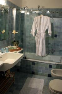 a bathroom with a white robe hanging on a shower at La Villeggiatura in Venice