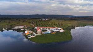 an island in the water with a house on it at Herdade da Urgueira in Vale de Pousadas