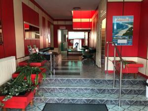a lobby of a building with red walls and plants at D.W. Grażyna in Niechorze