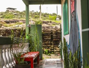 eine Veranda mit einer Bank und einem Gemälde an der Wand in der Unterkunft Sumé Hostel in São Thomé das Letras