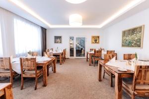 a dining room with wooden tables and chairs at Hotel U Kašny in Rajhrad