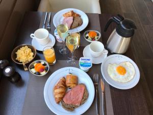 een tafel met borden met ontbijtproducten en -dranken bij Hotel Kristoffel in Middelkerke