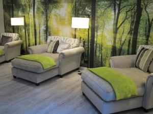 una sala de estar con 2 sofás y un mural forestal en Hotel Bären Titisee en Titisee-Neustadt