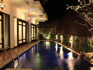 a swimming pool in the middle of a house at night at Baan Ratchiangsaen in Chiang Mai