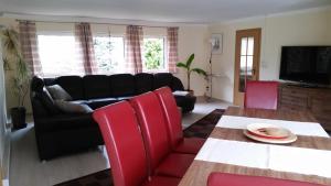 - un salon avec un canapé noir et des fauteuils rouges dans l'établissement Ferienhaus grüne Oase, à Halle-sur-Saale