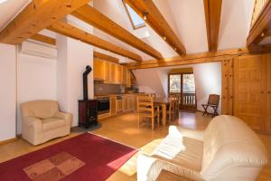 a living room with a white couch and a kitchen at Koritnica Apartments in Bovec +11 photos