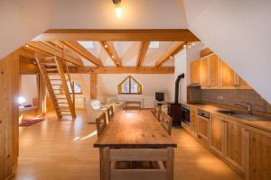 a kitchen with wooden cabinets and a table in a room at Koritnica Apartments in Bovec