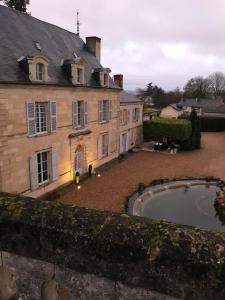 een oud huis met een zwembad ervoor bij Demeure de Beaulieu in Le Coudray-Macouard