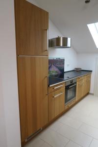 a kitchen with wooden cabinets and a stainless steel refrigerator at Ferienwohnung Reiteralmblick - Regina Häusl in Schneizlreuth +7 photos