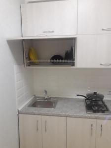 a kitchen counter with a sink and a stove at Апартаменты Оболонь in Kyiv