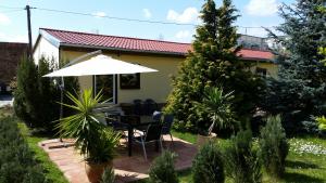 eine Terrasse mit einem Sonnenschirm, einem Tisch und Stühlen in der Unterkunft Ferienhaus grüne Oase in Halle an der Saale