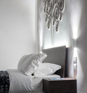 a bedroom with a bed with white sheets and pillows at Dada Suite in Naples