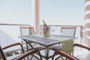 a blue table with glasses and a bottle of wine at Poolside Hideout Apartments in Novalja