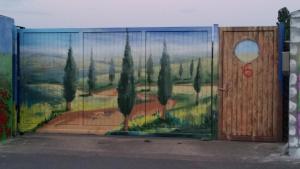 a wall with a painting of trees and a door at Ferienhaus grüne Oase in Halle an der Saale +4 photos
