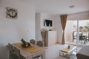 a living room with a table and a dining room at Poolside Hideout Apartments in Novalja