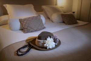 a hat sitting on top of a bed at Hostal Boutique Plaza Cantarero in Nerja