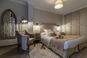 a bedroom with a bed and a chair at Hostal Boutique Plaza Cantarero in Nerja