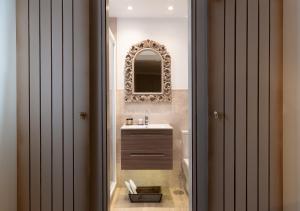 ein Badezimmer mit Waschbecken und Spiegel in der Unterkunft Hostal Boutique Plaza Cantarero in Nerja + 37 Fotos