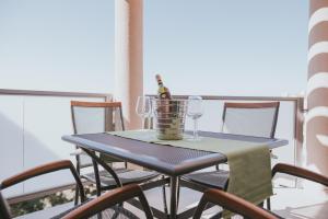 a table with a bottle of wine and glasses on a balcony at Poolside Hideout Apartments in Novalja