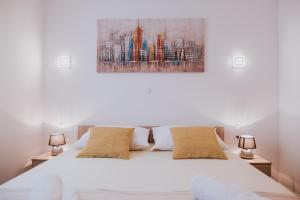 a bedroom with a white bed with two lamps at Poolside Hideout Apartments in Novalja