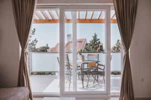 a room with a balcony with a table and chairs at Poolside Hideout Apartments in Novalja