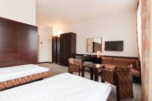 ヤブロネツ・ナド・ニソウにあるホテル メルクール ヤブロネツ・ナド・ニソウのベッド2台とデスクが備わるホテルルームです。
