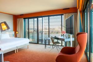 a hotel room with a bed and a desk and a window at Radisson Blu Hotel Bordeaux in Bordeaux