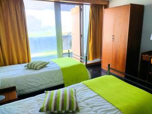 
a hotel room with two beds and two lamps at HI Viana do Castelo - Pousada de Juventude in Viana do Castelo
