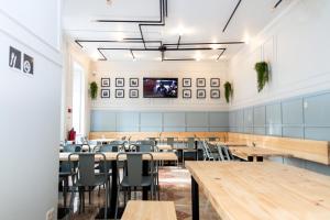 a dining room with tables and chairs and a flat screen tv at Sant Jordi Hostels Lisbon in Lisbon