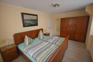 Schlafzimmer mit einem Bett mit gestreifter Decke in der Unterkunft Ferienwohnung Moog in Lonnig