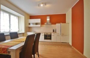 eine Küche mit Tisch und Stühlen und einem Kühlschrank in der Unterkunft Ferienwohnung Moog in Lonnig