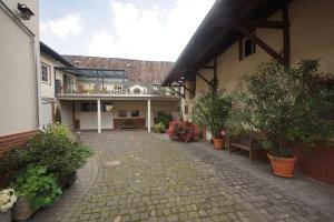 einen Innenhof eines Hauses mit Topfpflanzen und einem Gebäude in der Unterkunft Ferienwohnung Moog in Lonnig