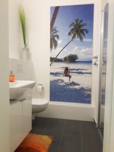 a bathroom with a toilet and a view of the beach at Top-Apartment a.d. Messe in Munich