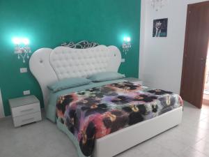 a bedroom with a white bed with a floral blanket at B&B Romy in Tropea