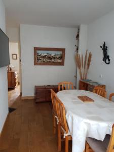 a dining room with a white table and chairs at Appartement Cap Horn in Le Mont-Dore