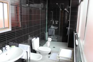 y baño con aseo, lavabo y ducha. en Casa Ermita 20 - Centro Ronda by CasaTuristica, en Ronda