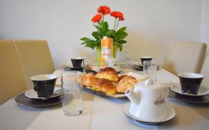 a table with a plate of croissants and tea pots at Red & Blu Apartments in Desenzano del Garda +134 photos