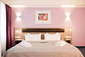 una camera da letto con un letto con due asciugamani sopra di Hotel Nikolai Residence a Berlino