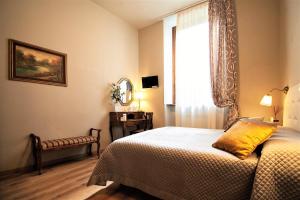 a bedroom with a bed and a window at La Colonna (Historic Centre) in Lucca
