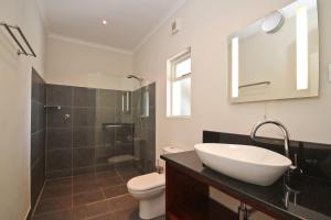 a bathroom with a sink and a toilet and a shower at Montrose Guesthouse in Somerset West