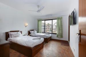 una camera d'albergo con due letti e una finestra di Pacific Guest House a Kathmandu