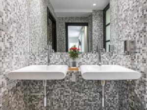 a bathroom with two sinks and a mirror at Martini Castello Boutique Rooms - Historic Center & Cathedral in Cagliari
