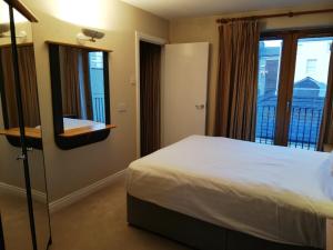 a bedroom with a bed and a large window at Molesworthcourt Suites in Dublin