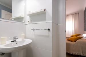 a white bathroom with a sink and a bed at Hostal Luna de Nerja in Nerja +62 photos