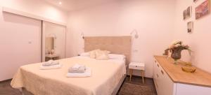 una camera da letto bianca con due asciugamani su un letto di L'ArcoBaleno a Rovigno (Rovinj)