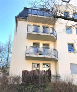 ein weißes Gebäude mit Balkon auf der Seite in der Unterkunft Modernes Apartment Dresden Neustadt in Dresden